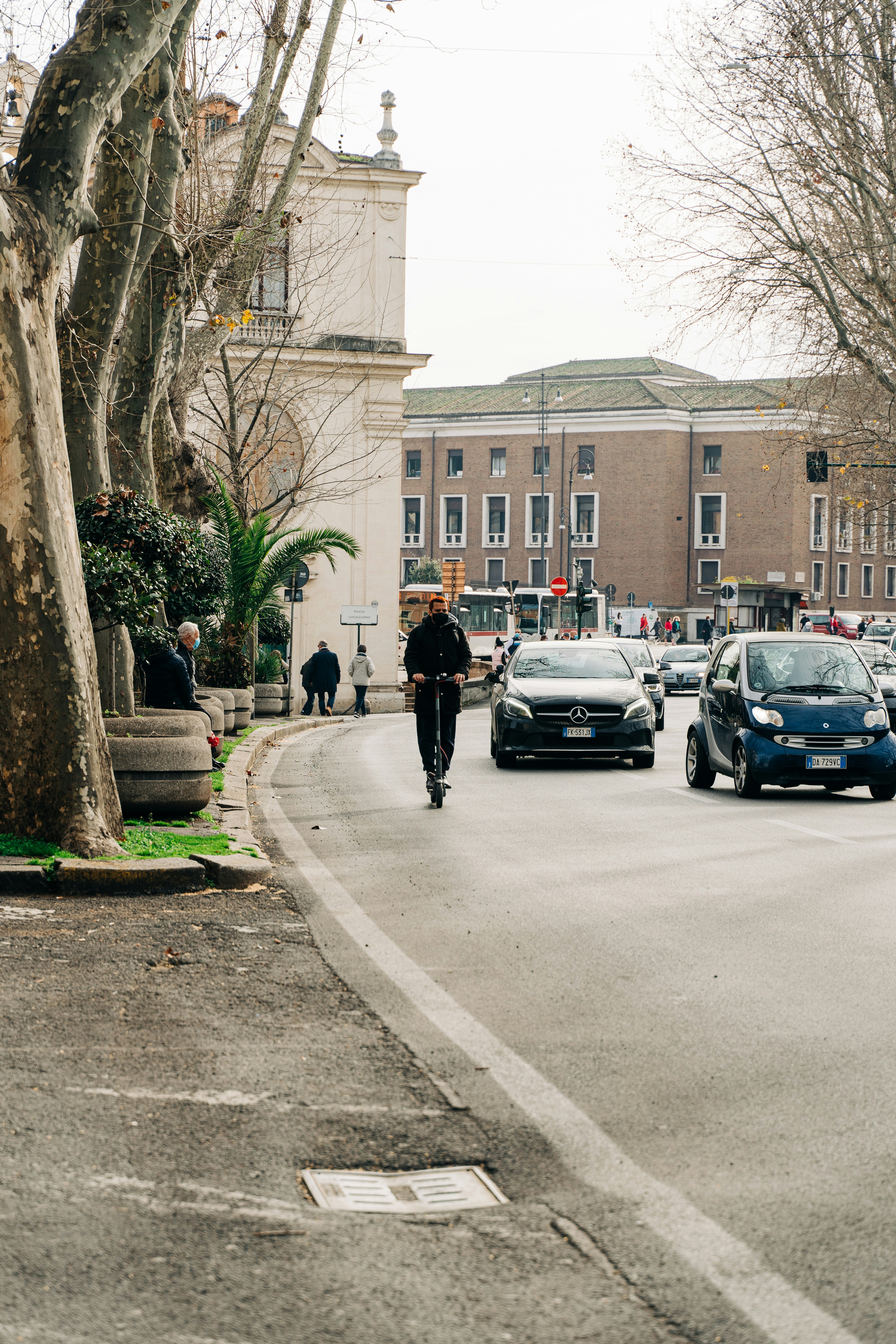 man in black jacket walking on sidewalk during daytime